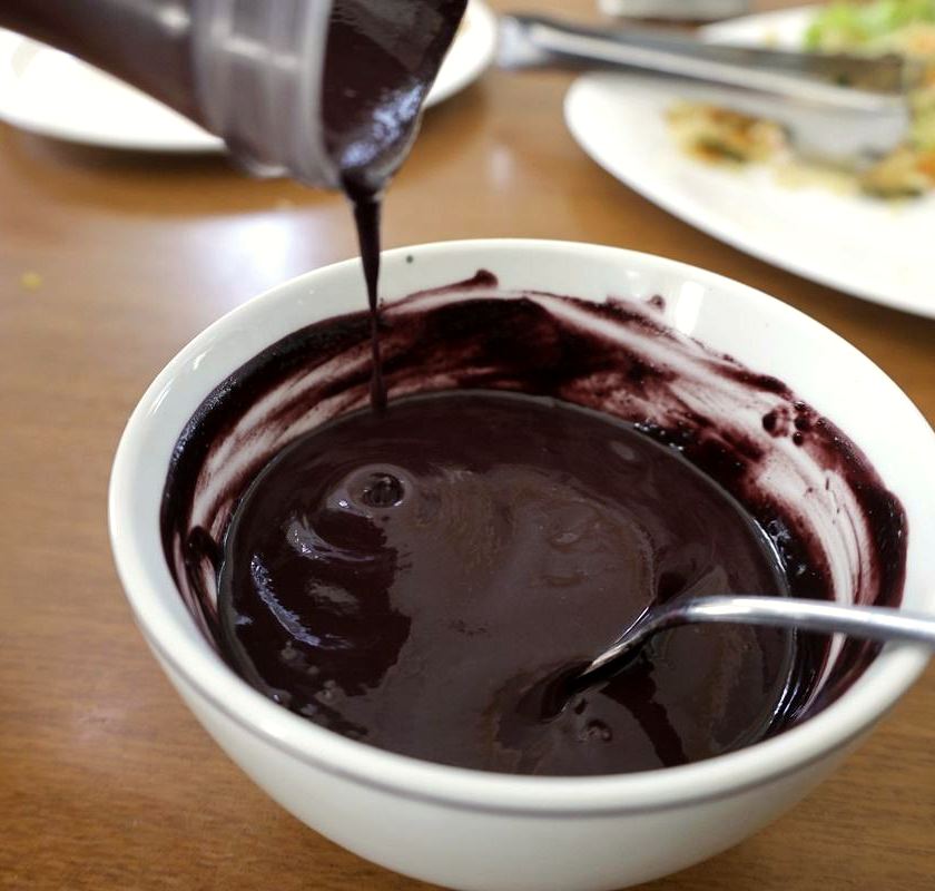 Açaí puro sendo despejado numa tigela branca
